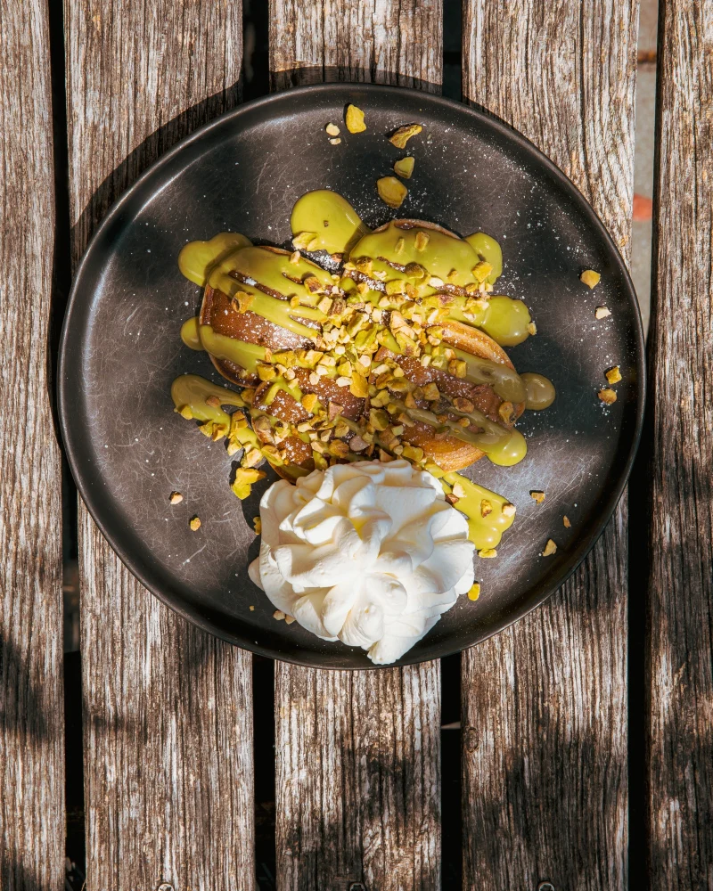 Dessert with pistachio sauce, chopped pistachios and whipped cream