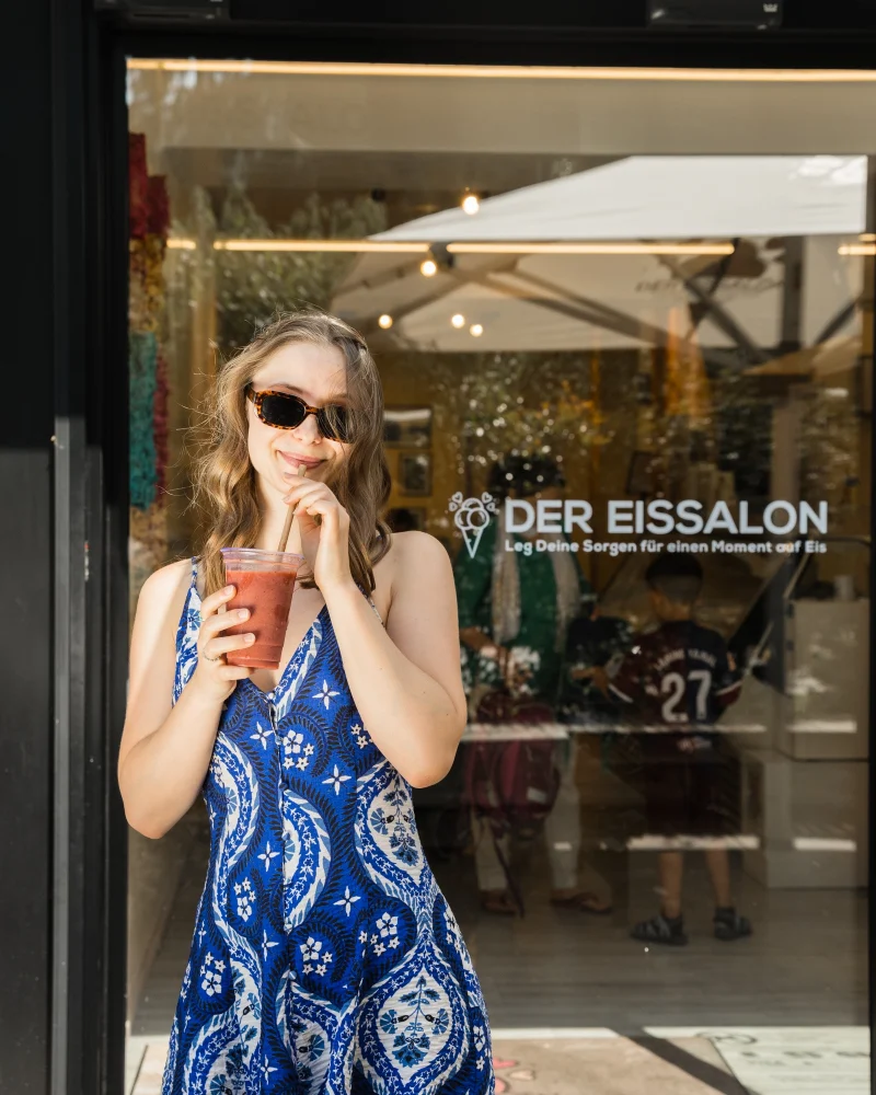 Woman with a drink at the entrance of Der Eissalon on Straßganger Straße, Graz-Wetzelsdorf